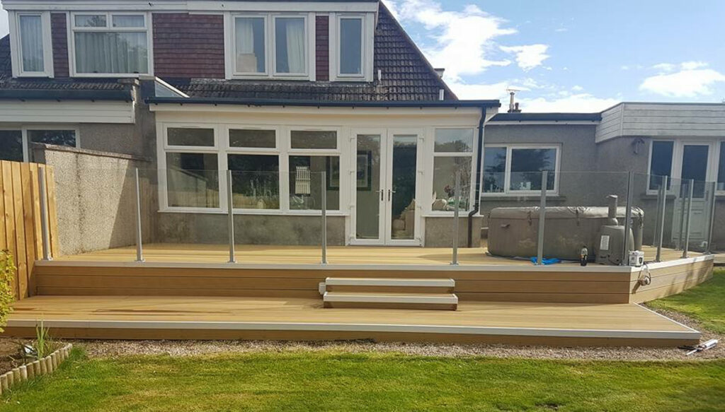 New conservatory and decking with glass balustrade