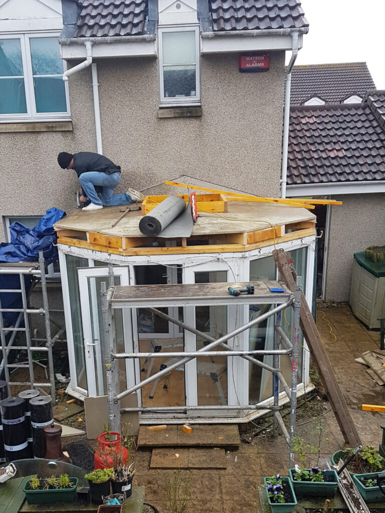 Roofer at work building replacement conservatory roof in Aberdeen